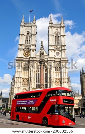 LONDON, UK - JULY 9, 2014: Modern double-decker red bus passes the famous Westminster Abbey in central London.