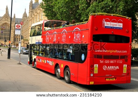 LONDON, UK - JULY 9, 2014: Modern double-decker red bus passes the famous Westminster in central London.