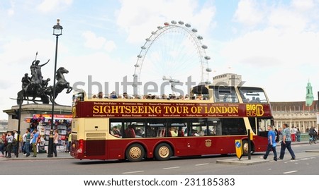 LONDON, UK - JULY 9, 2014: Tourists sightseeing London Eye in central London from a tour bus.