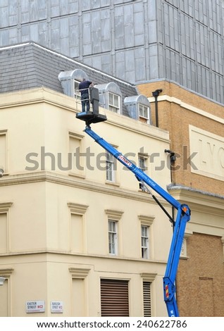 LONDON, UK - JULY 9, 2014: Window washer doing work on a historical building in central London