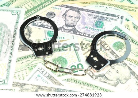 Financial crime concept with handcuffs on money background