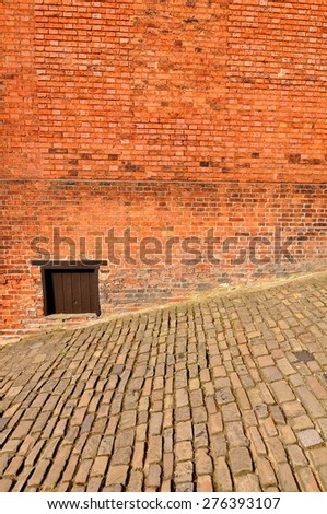 Abstract view of old cobbled streets and red brick wall
