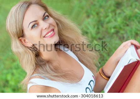 Girl with a book. Portrait of a beautiful girl with a book. The girl on the nature. Girl reading a book.