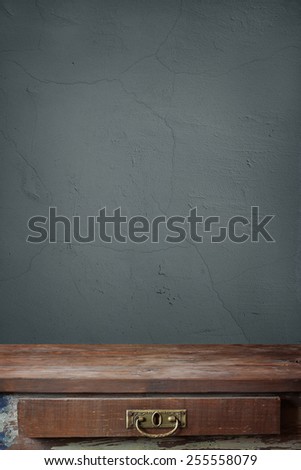 empty wooden table with a box against a blue wall