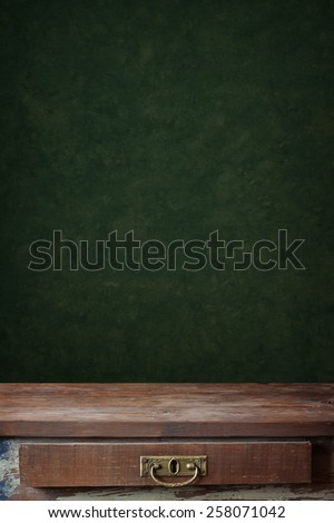empty wooden table with a box against a wall