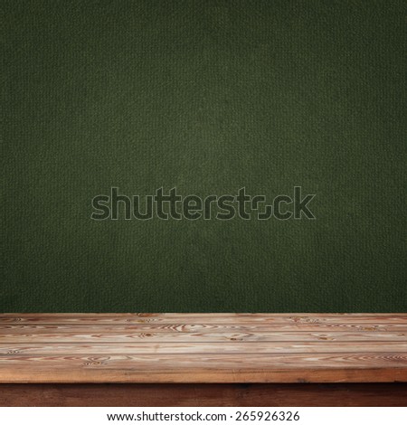 empty wooden table with a box against a green wall