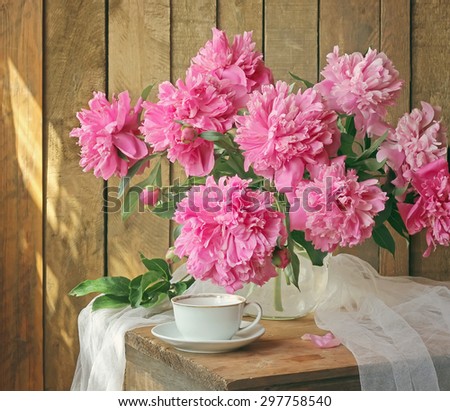Still life with a bouquet of peonies and a cup