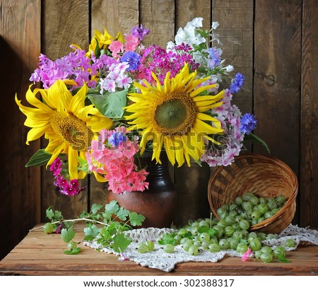 Still life with a bouquet of sunflowers and phloxes. Flowers and berries.