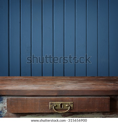 Empty wooden table against a wall from the boards painted in blue color. Background, texture. A blank space for.
