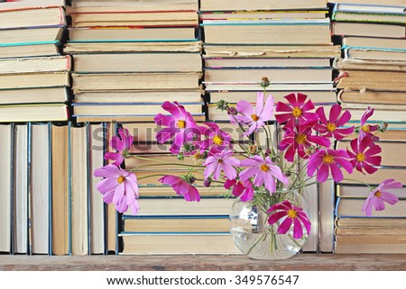 Bouquet in a transparent round vase against from books.  A background from books.