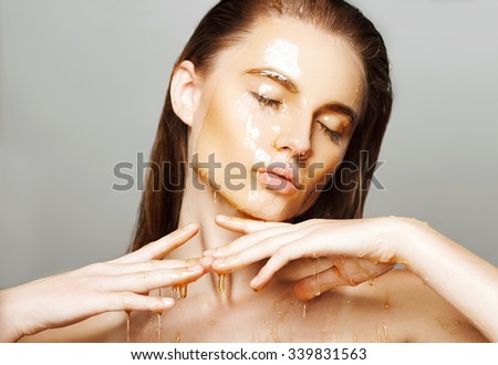 Beautiful woman with honey on her face. Healthy perfect skin. Honey treatment.