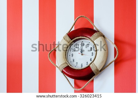 The clock on the wall in red and white stripes in the interior of a child's room