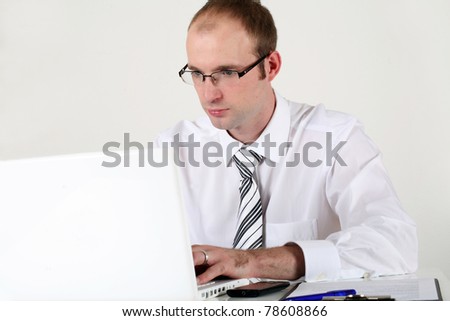 Young businessman at working on computer and thinking