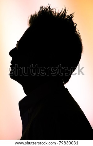silhouette of a young  man in sunglasses  on white orange background - back-lighting