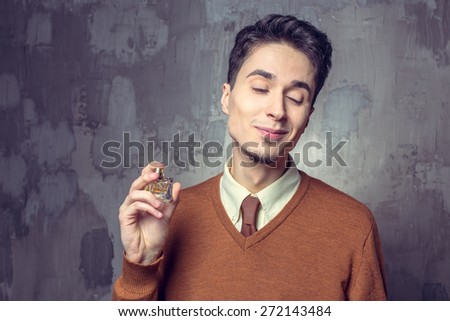 Young man spraying perfume