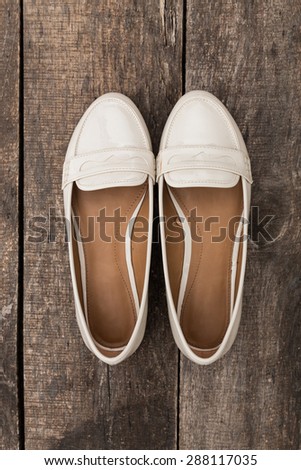 girl shoes over wooden deck floor.