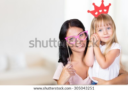 Mother and daughter having fun with photo props