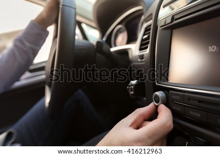 Hand Pushing the power button to turn on the car stereo system