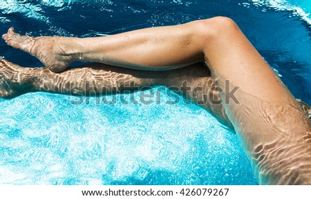 Beautiful woman legs in swimming pool.