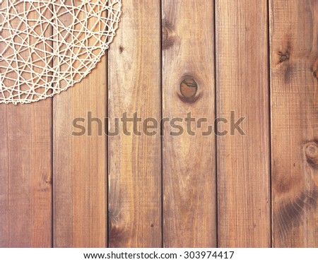 Round rope napkin or stand on a wooden rustic table. To create a collage with food. View from top.