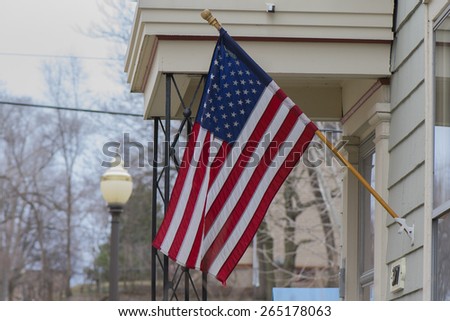 An American flag being proudly placed outside an American home.