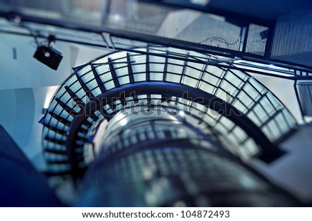 Modern glass spiral stairway. Tilt shift effect used to accent the movement and the modern lines. Useful file for your architectural magazine, brochure, article and other media need.