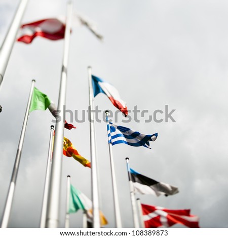 National flags of various European countries with Greek flag in the center, in front of the official seat of the European Parliament