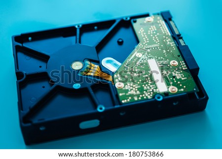 Computer hard drive on blue background (HDD, Winchester). Tilt-shift lens used to accent the center of the hdd and to emphasize the attention its central schemes