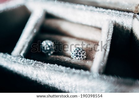 Pair of blue diamond crystal earrings in luxurt storage box - beautiful jewelry - tilt-shift lens used to outline the object and to emphasize the attention on them