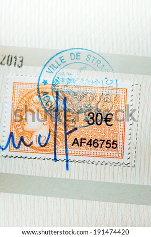 PARIS, FRANCE - APRIL 10, 2014: Revenue stamp or tax stamp or fiscal stamp issued by Republic of France in a value of 30 Euros, marked with a seal and signature as seen on a document on April 10, 2014