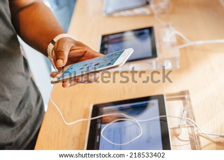 PARIS, FRANCE - SEPTEMBER 20, 2014: Man trying the new iPhone 6 Plus at the Apple Inc. store in Paris, France