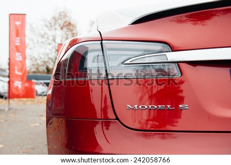 PARIS, FRANCE - NOVEMBER 29, 2014: Tesla Model S signage of a red car at Paris showroom, France. Tesla is an American company that designs, manufactures, and sells electric cars