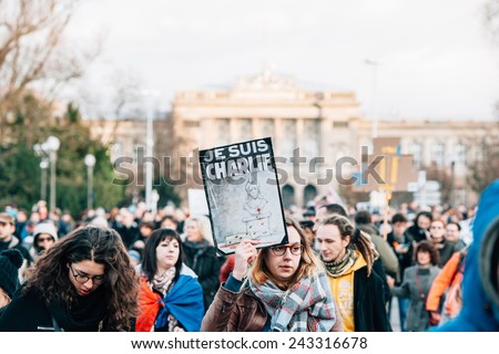 STRASBOURG, FRANCE - 11 JAN, 2015:  Girl hold placards reading \'Je suis Charlie\' during a unity rally (Marche Republicaine) where some 50000 took part in tribute three-day killing spree in Paris