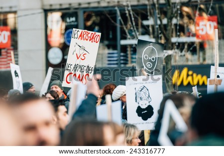 STRASBOURG, FRANCE - 11 JAN, 2015:  People hold placards reading \'Art-Deco vs Guns\' during a unity rally (Marche Republicaine) where some 50000  took part in tribute three-day killing spree in Paris