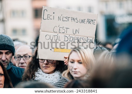 STRASBOURG, FRANCE - 11 JAN, 2015:  People hold placards reading \'This is not a gun, this a thing to express myself\' during a unity rally (Marche Republicaine) where some 50000 people took part