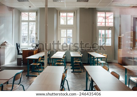 Empty classroom with large windows and old furniture