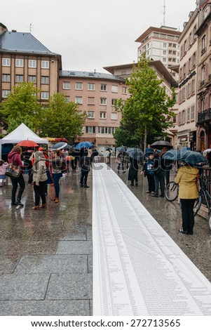 STRASBOURG, FRANCE - APR 26 2015: People reading long list at protest against immigration policy and border management which asks for commitment in the wake of migrants boat disasters