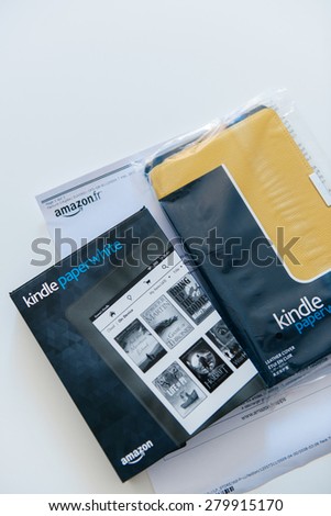 PARIS, FRANCE - MAY 13, 2015: Amazon Kindle Paperwhite and yellow Kindle leather cover above the Amazon invoice. The Amazon Kindle is a series of e-book readers designed and marketed by Amazon.com.