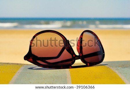 Sun glasses at the beach on a sunny and moody day