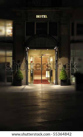 Night shot of the entrance and facade to a luxury hotel.