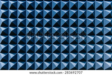 Blue abstraction on a wall composed of blue bricks with sun shades