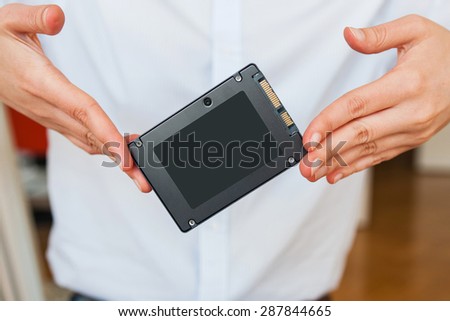 Hands holding fast flash SSD - solid state drive
