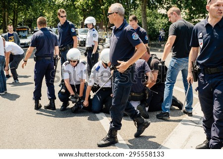 STRASBOURG, FRANCE - JULY 11, 2015: Police arresting man - Uyghur human rights activists participate in a demonstration to protest against Chinese government\'s policy in Uyghur