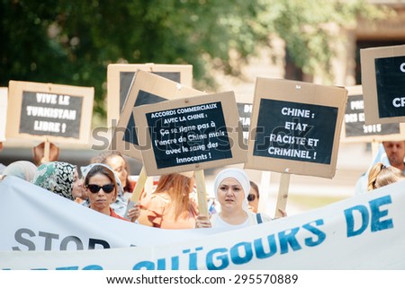 STRASBOURG, FRANCE - JULY 11, 2015: China rasist and crimial country placard - Uyghur human rights activists participate in a demonstration to protest against Chinese government\'s policy in Uyghur