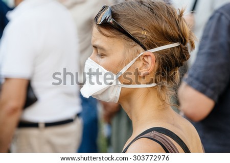 STRASBOURG, FRANCE - AUG 6, 2015: People wearing air masks protesting against air pollution in Strasbourg, Alsace, France - woman wearing mask
