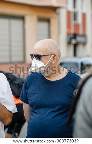 STRASBOURG, FRANCE - AUG 6, 2015: People wearing air masks protesting against air pollution in Strasbourg, Alsace, France - old man wearing polution mask