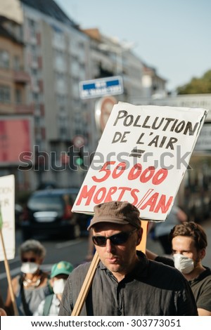 STRASBOURG, FRANCE - AUG 6, 2015: People wearing air masks protesting against air pollution in Strasbourg, Alsace, France - man protesting with placard: 50000 dies yearly from pollution