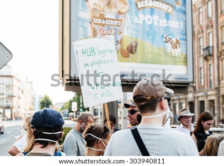 STRASBOURG, FRANCE - AUG 6, 2015: People wearing air masks protesting against air pollution in Strasbourg, Alsace, France - placard: logistic platforms in downtown