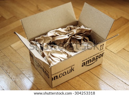 LONDON, UNITED KINGDOM - MARCH 05, 2014: Opened Amazon.co.uk shipping package parcel box on wooden floor with protection paper inside. Amazon.com went online in 1995 and the largest online retailer