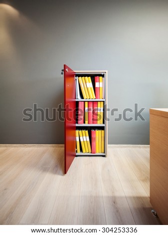 Modern office cabinet with open door and an array of files kept on shelves
